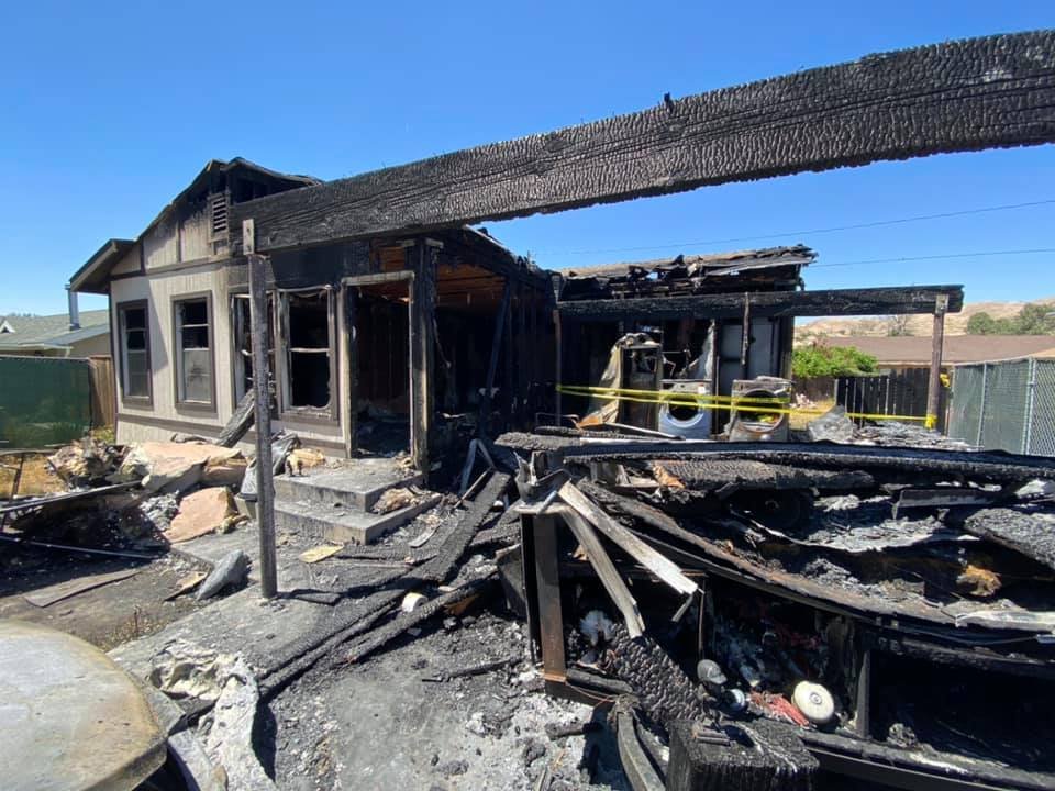 Fire-damaged single-storey home with charred framing and debris